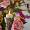 led theelichtje van dorsetto op houder op de achtergrond zijn bloemen