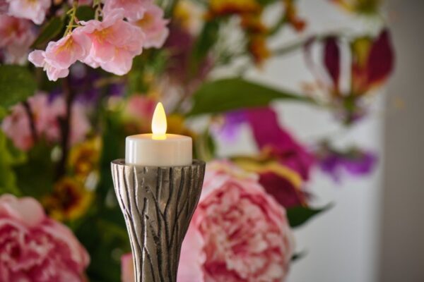 led theelichtje van dorsetto op houder op de achtergrond zijn bloemen