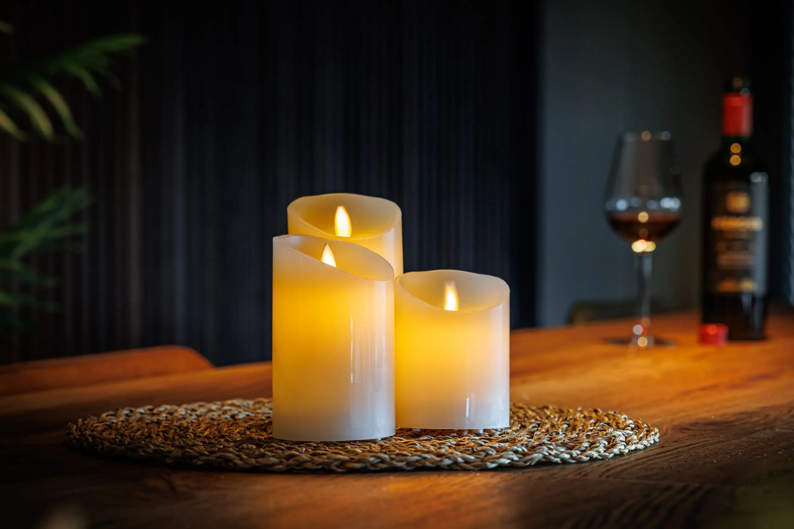 Led kaarsen set van ledwaxinelichtjes.nl op onderzetter op tafel met wijnfles en wijnglas.